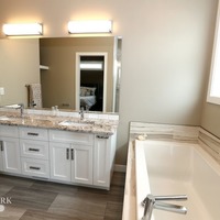Medium 19 emerald hill dr. show home for sale by emerald park homes white city walk out bungalow master ensuite bathroom with dual sinks drop in tub and shower with bench tile 1024x683